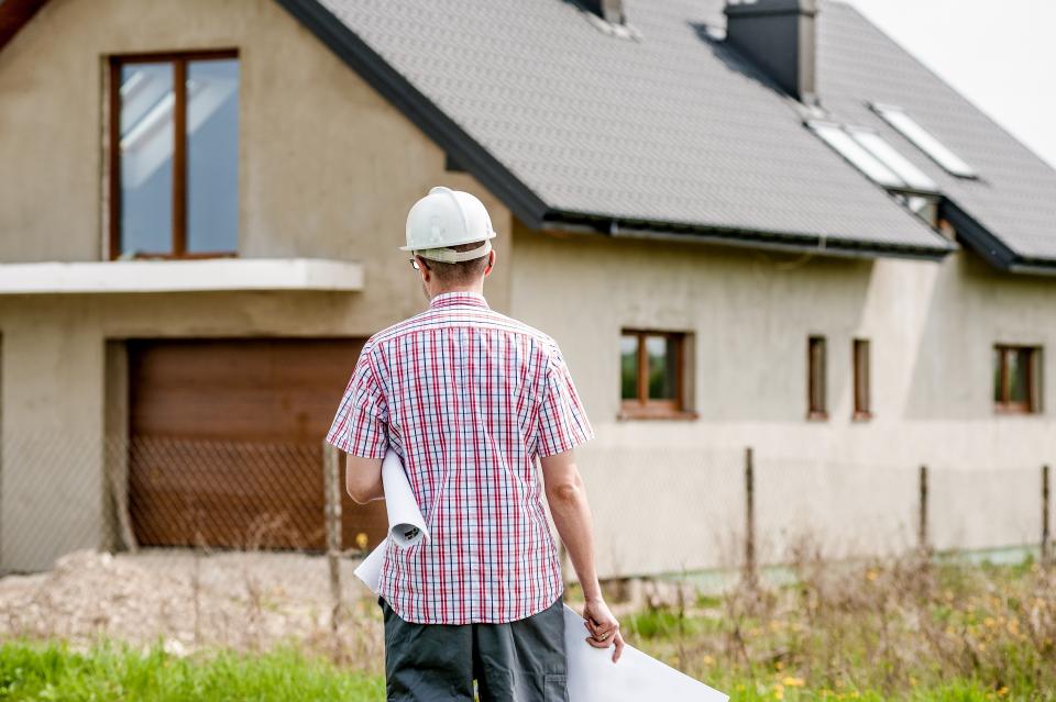 Conducteur de travaux consultant des plans devant un bâtiment